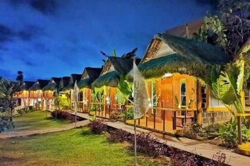 a row of cottages with green plants in the yard at Your Brothers House Tribal Village in Legazpi