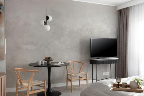 a living room with a tv and a table and chairs at Flatbook - City Center Apartments Dwie Motławy in Gdańsk