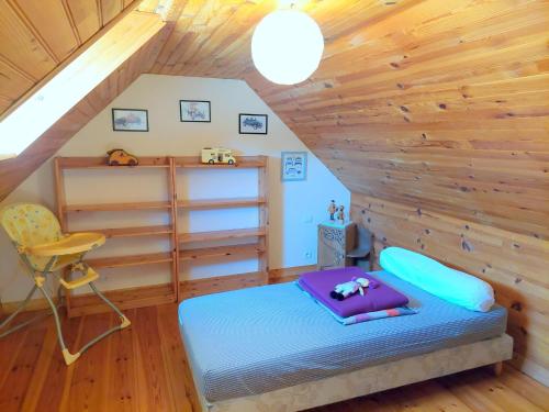 Cottage, Plouenan في Plouénan: غرفة بسرير وكرسي في العلية