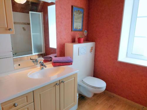 a bathroom with a sink and a toilet and a mirror at Stone House near Penze River and Morlaix Bay in Plouénan