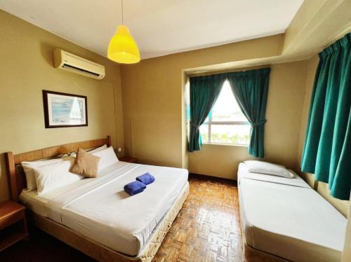 1 dormitorio con 2 camas y ventana en Maya Apartment Bay View Villas, en Port Dickson