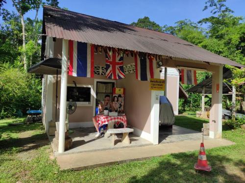 Una pequeña casa con una bandera. en Suan Bang Bon Guest House, en Plai Phraya