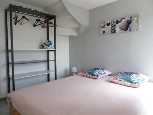 a bedroom with a bed with two pillows on it at Charming, fully renovated stone house in Bricqueville-sur-Mer