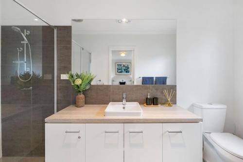 a white bathroom with a sink and a shower at Ocean Haven in Aireys Inlet