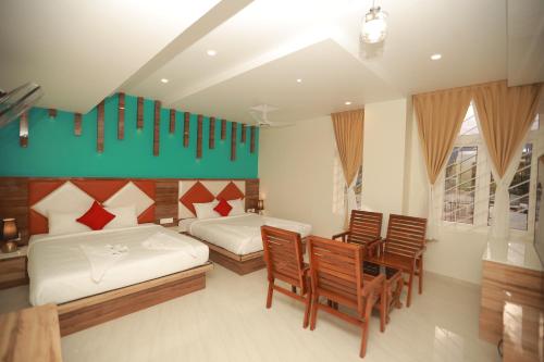 Alāndurai的住宿－Sree Bharat Residency，一间卧室配有两张床和一张桌子及椅子