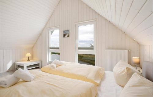 オルペニッツにあるBeautiful Home In Ostseeresort Olpenitz With Saunaの白い部屋 ベッド2台 窓2つ付