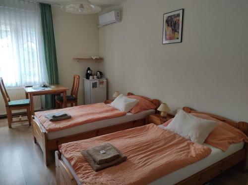 a room with two beds and a kitchen with a table at Montana-Ederics Vendégház in Balatonederics