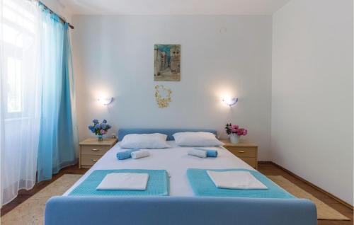 a bedroom with a blue bed with two pillows on it at Cozy Home In Grizane With Kitchen in Grižane