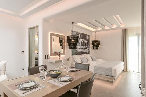 a white living room with a dining table and a bed at Naxos Pantheon Luxury Apartments in Agkidia
