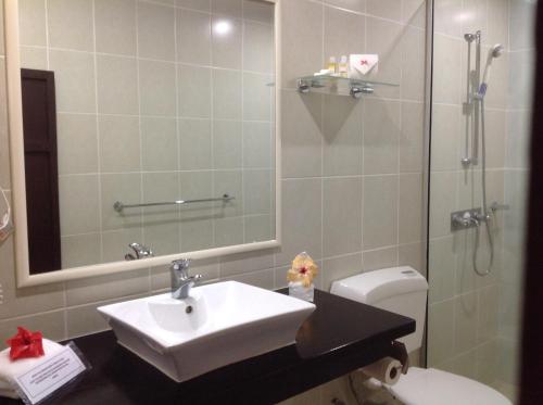 a bathroom with a sink and a shower and a toilet at Gecko's Resort in Sigatoka