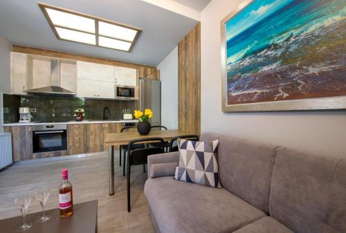 ein Wohnzimmer mit Sofa und eine Küche in der Unterkunft Rena's luxury apartment with free private parking in Chania