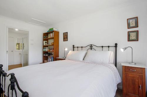 a bedroom with a large bed with a white bedspread at Cooinda in Apollo Bay