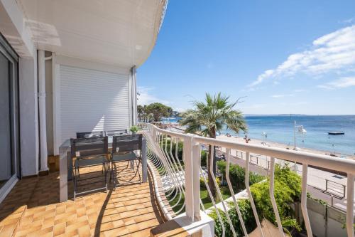 - un balcon avec une table et des chaises et la plage dans l'établissement SERRENDY  RARE !  Superbe appartement avec vue sur la mer , à Cannes