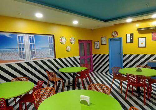 restauracja z zielonymi stołami i krzesłami w pokoju w obiekcie Asian Suites IFFCO Metro Station Gurugram w mieście Gurgaon