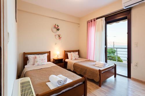 two beds in a room with a view of the ocean at Seaside Getaway - Aelia Villa's Dreamy Paradise in Petalidhion