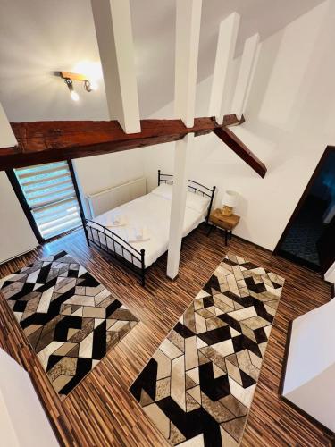 Habitación en el ático con cama y alfombra en Apartament in regim hotelier King Medias, en Mediaş