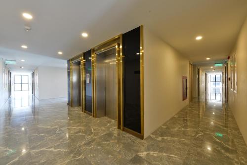 a hallway with glass doors and a marble floor at Grand BS Airport Hotel Suvarnabhumi in Lat Krabang