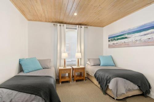 a bedroom with two beds and a window at Cora Lynn 13 in Lorne