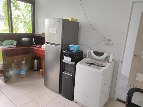 a kitchen with a refrigerator and a washing machine at Horse Riding Next Door in Yuanshan