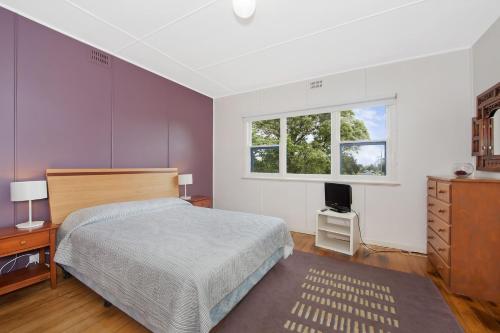 a bedroom with a bed and a dresser and a window at Anderson in Apollo Bay