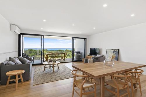 a living room with a table and chairs and a couch at Joy Apartment 1 in Lorne