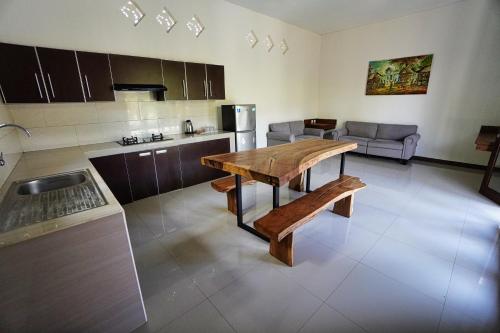 a kitchen and living room with a wooden table at Adil Villa & Resort in Ubud