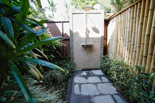 a garden with a gate and a walkway at Adil Villa & Resort in Ubud
