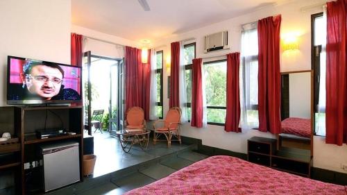 a bedroom with a bed and a tv and windows at B Nineteen in New Delhi