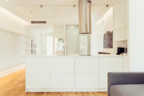 a white kitchen with white cabinets and a chair at Marina Gardens Boutique&Suites in Francavilla al Mare