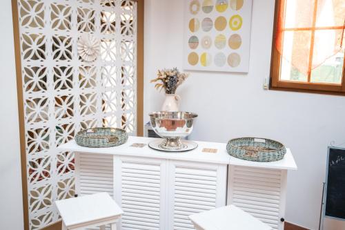 una habitación con 2 taburetes y un armario blanco con un tazón de cristal en LA VILLA BOLERO, en Saint-Cyr-sur-Loire