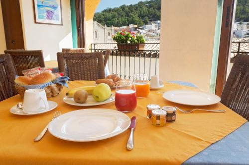 a table with plates of food on a yellow table cloth at Hotel Clelia in Ustica