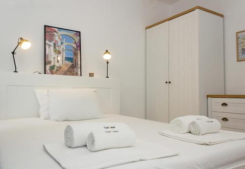 - une chambre blanche avec 2 serviettes sur un lit dans l'établissement The Residential 1-BD Apartment with an Outdoor Thermal Pool by Flat Mаnager, à Varna