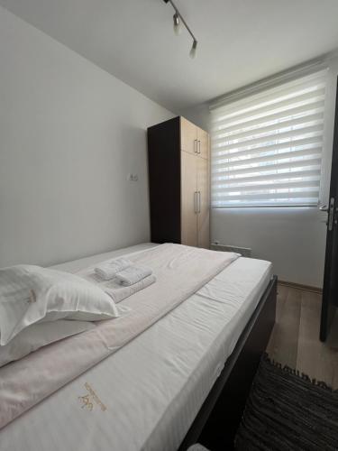 科帕奥尼克Kraljevi Cardaci Olja的带窗户的房间里有一张白色的床