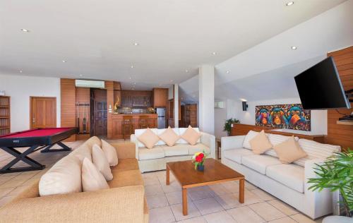 a living room with couches and a pool table at Beachfront Kalim Beach Villa in Patong Beach