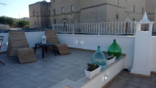 a patio with chairs and vases on a balcony at La loggetta 63 in Palagianello