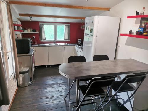 cocina con mesa, sillas y nevera en Mobil home hors camping, en Roquebrune-sur-Argens
