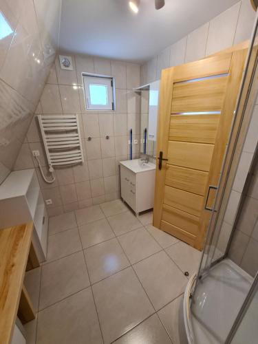a bathroom with a shower and a sink and a door at Filarówka in Łeba