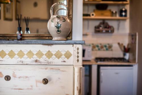a kitchen with a white dresser with a vase on it at Casa Crevole di Martina in Murlo