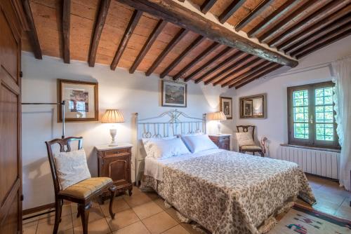 1 dormitorio con 1 cama y 2 sillas en Casa Crevole di Martina en Murlo