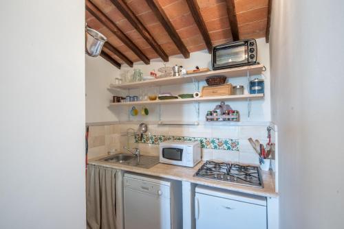 a small kitchen with a stove and a microwave at Casa Crevole di Martina in Murlo