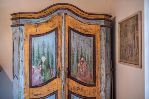 a wooden door with paintings on it in a room at Casa Crevole di Martina in Murlo