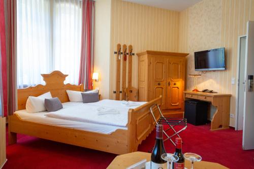 a bedroom with a large wooden bed in a room at Hotel & Restaurant Waldschlösschen in Kyritz