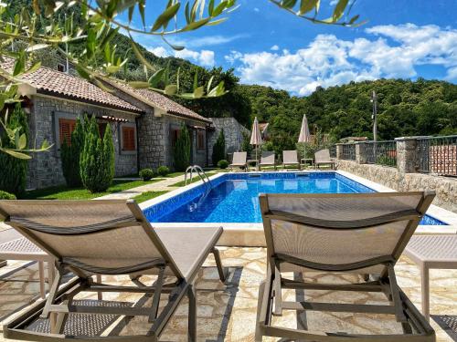een patio met 2 stoelen en een zwembad bij Eco Villas Merak in Virpazar