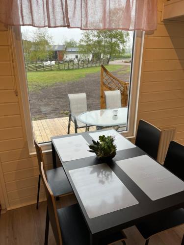 a dining room with a table and a window at Rödlix Vandrarhem & Camping in Tvååker
