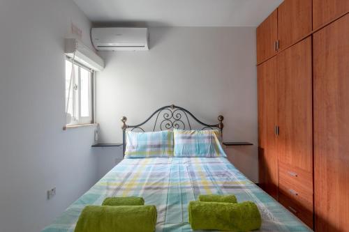 a bedroom with a bed with two green chairs at Sea view apartment in St Paul's Bay in St. Paul's Bay