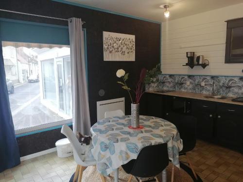 a kitchen with a table with a vase on it at Gîte cosy la Mosaïque, à Selles-sur-Cher, 15 mn du zoo Beauval in Selles-sur-Cher