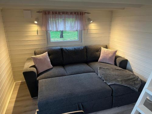 a couch in a small room with a window at Rödlix Vandrarhem & Camping in Tvååker