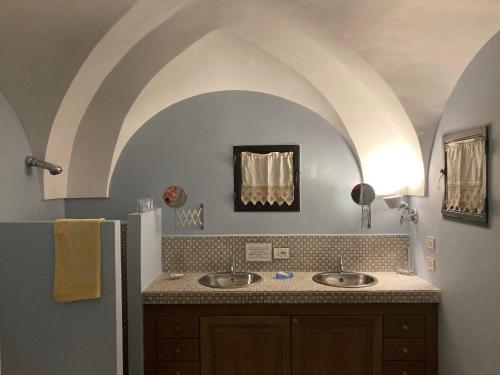 a bathroom with two sinks and an arched ceiling at Residenza delle Palme in Pantelleria
