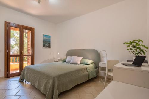a white bedroom with a bed and a window at House of Lens in Golfo Aranci