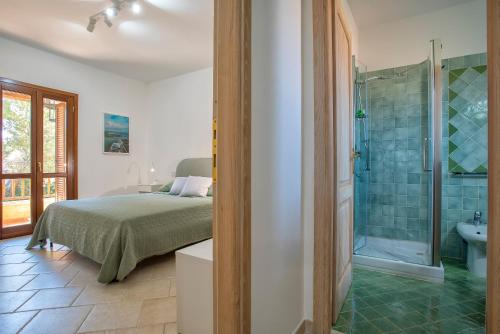 ein Schlafzimmer mit einem Bett und ein Badezimmer mit Dusche in der Unterkunft House of Lens in Golfo Aranci